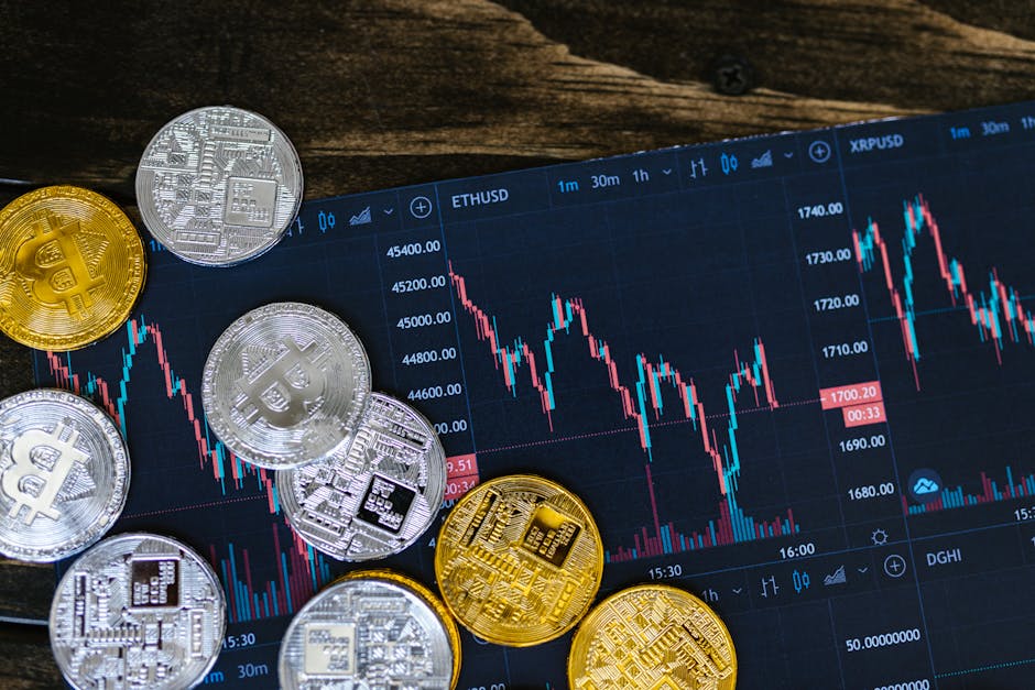 Close-up of gold and silver cryptocurrency coins on a digital trading chart