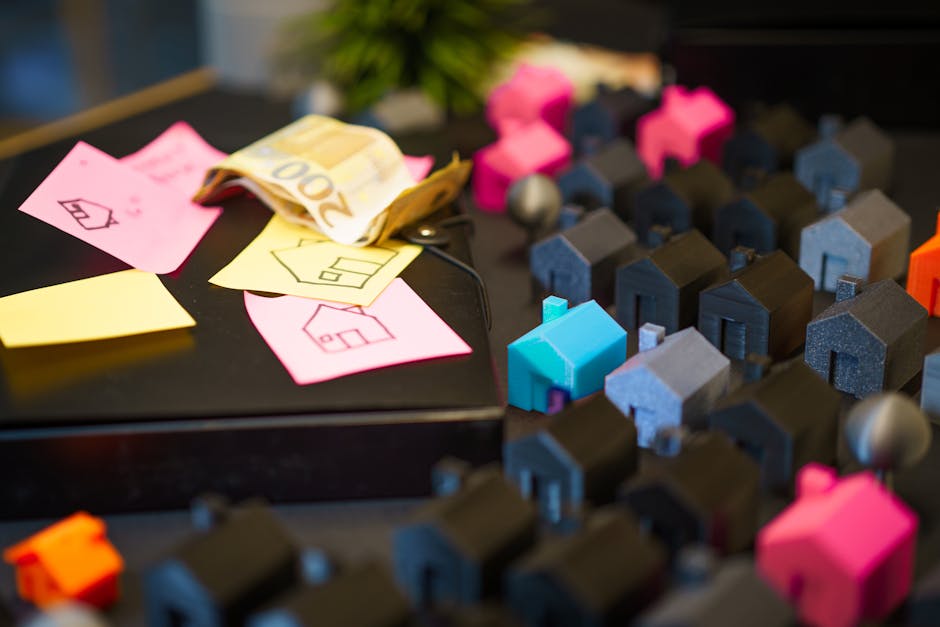 Colorful model houses next to Euro notes and sketches, showcasing real estate investment planning