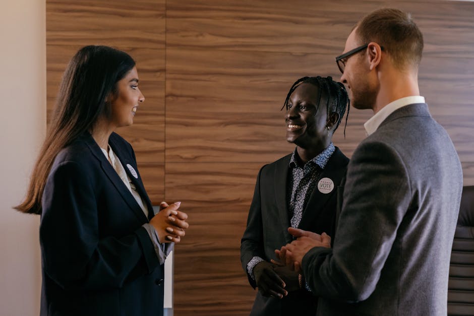 Three professionals engaged in conversation within a modern conference room setting